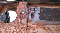 Rusted body mount brace on bottom of brake reservoir well